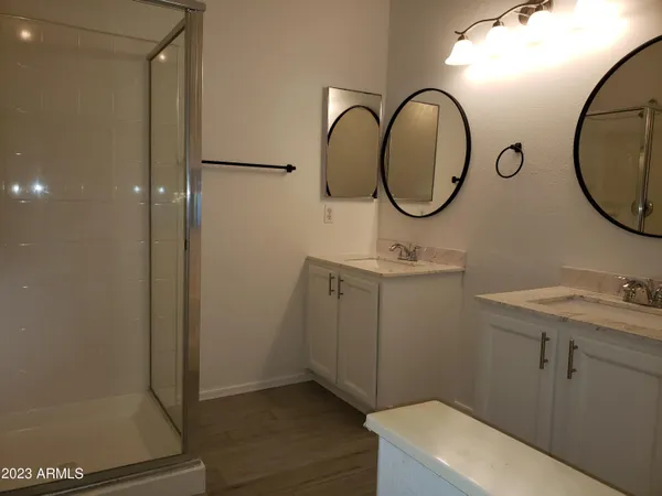 a bathroom with a sink a mirror a vanity and a shower