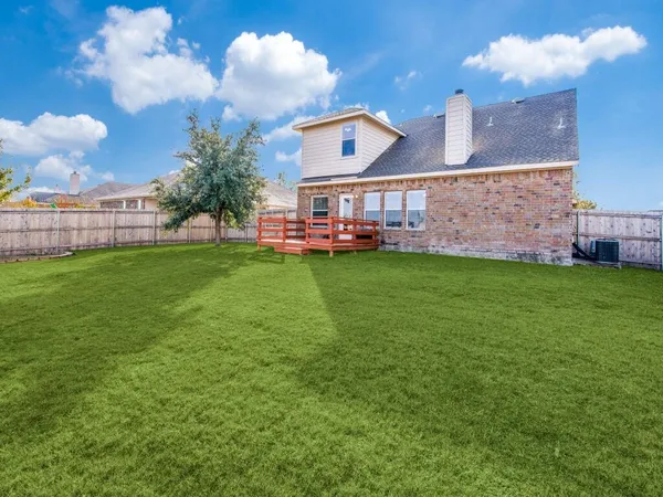 a view of a big yard with a house in the background
