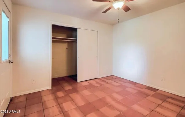 a view of an empty room with a ceiling fan
