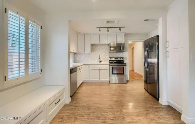 a kitchen with stainless steel appliances a refrigerator and a stove top oven