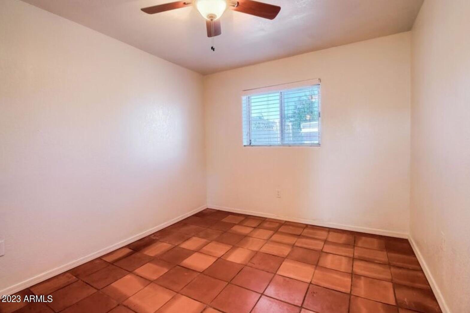 1430 East Meadowbrook Avenue Phoenix, AZ 85014 - Photo 4 of 18 an empty room with a ceiling fan and window