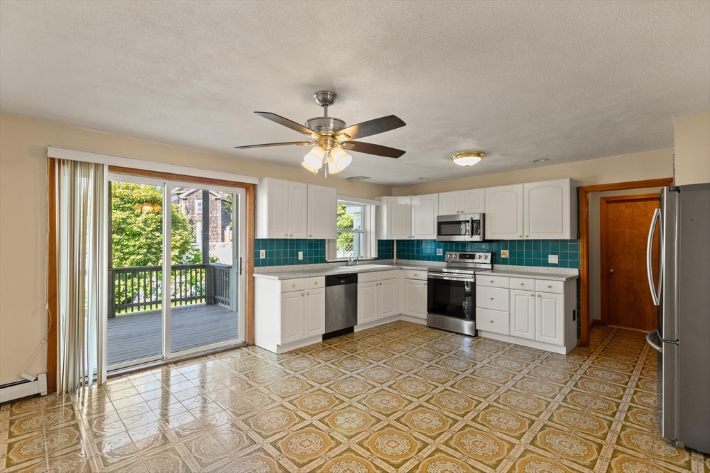 5 Washington Square Gloucester, MA 01930 - Photo 18 of 20 a kitchen with a refrigerator a sink and cabinets