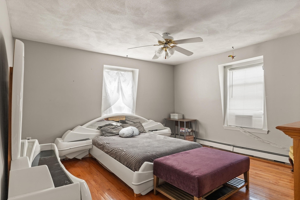 5 Washington Square Gloucester, MA 01930 - Photo 9 of 20 a bedroom with a bed and wooden floor