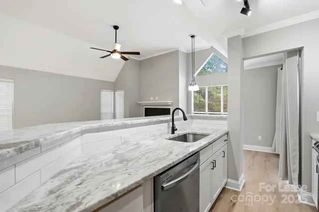 a kitchen with granite countertop a sink a counter top with appliances and cabinets