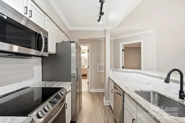 a kitchen with stainless steel appliances granite countertop a sink and a stove
