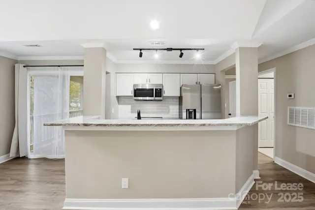 a kitchen with stainless steel appliances a sink and a refrigerator