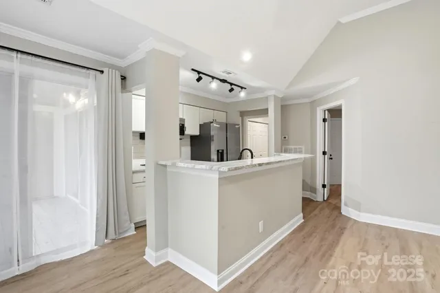 a view of a hallway with bathroom and wooden floor