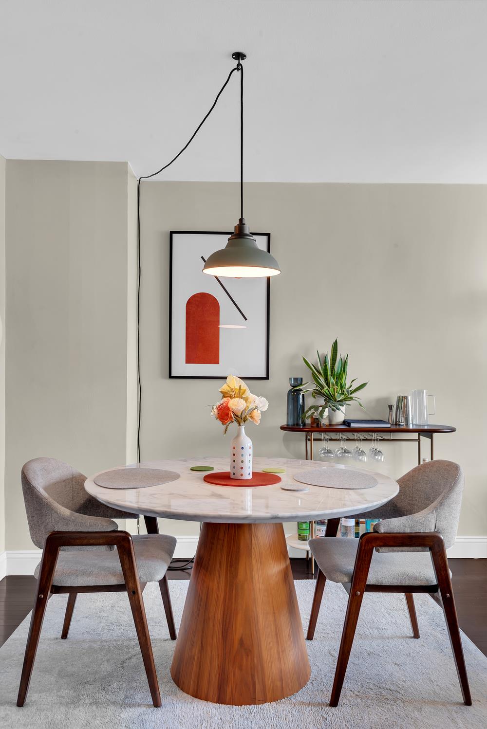 77 7th Avenue, Unit 14L Manhattan, NY 10011 - Photo 2 of 10 a room with a table chairs and a potted plant