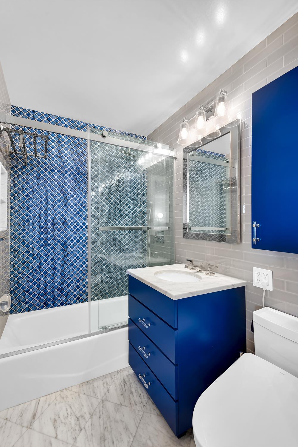 77 7th Avenue, Unit 14L Manhattan, NY 10011 - Photo 7 of 10 a bathroom with a sink and a mirror
