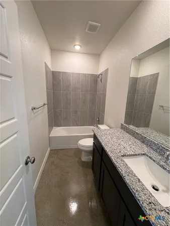 a bathroom with a granite countertop sink a toilet and bathtub