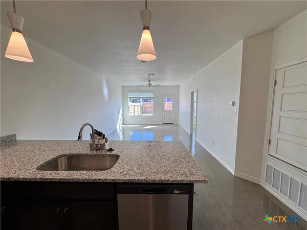 en empty room with windows and ceiling fan