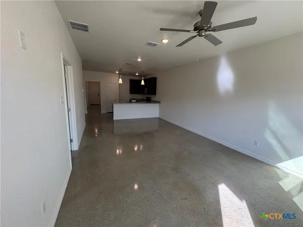 an empty room with a window and a fan