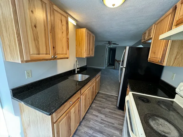 a kitchen with wooden cabinets a sink and a window