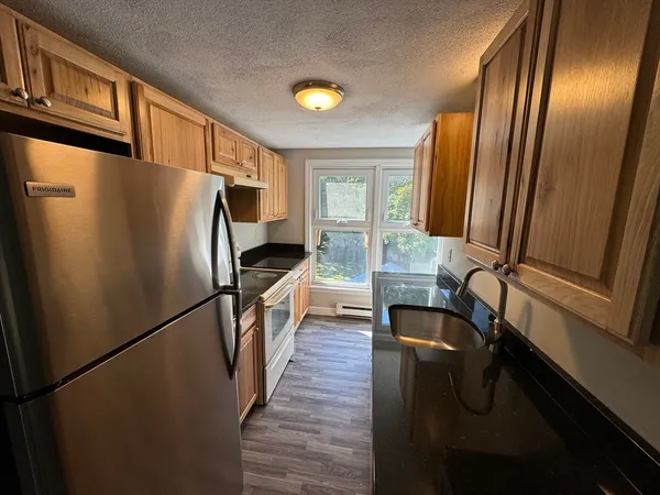 a kitchen with granite countertop stainless steel appliances a refrigerator a stove a microwave and a refrigerator
