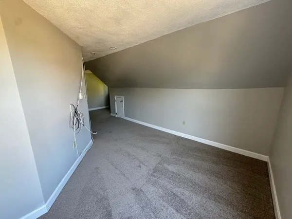 a view of a big room with wooden floor and stairs