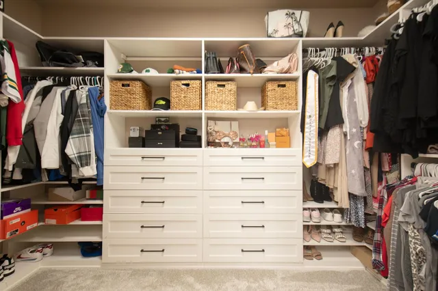 a bedroom with a bed a dresser and a window