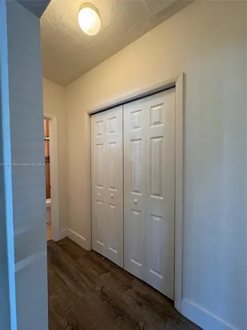 an empty room with wooden floor and closet area