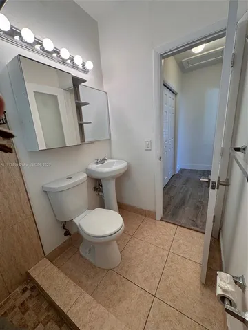 a bathroom with a toilet sink and mirror