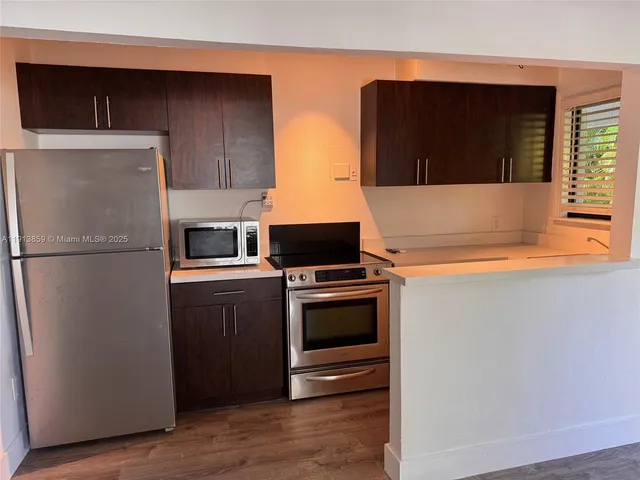 a kitchen with stainless steel appliances granite countertop a refrigerator and a stove