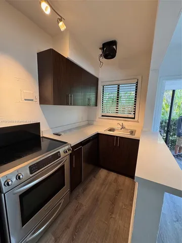 a kitchen with stainless steel appliances a stove a microwave and a hard wood floor