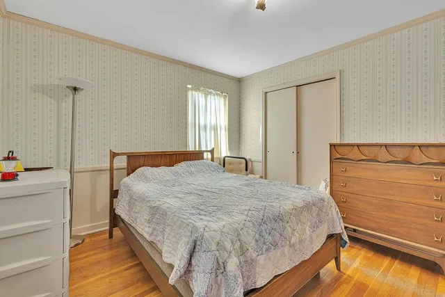 a spacious bedroom with a large bed and dresser with mirror