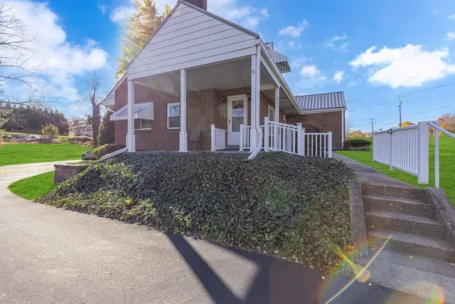 a view of a house with a yard and pathway