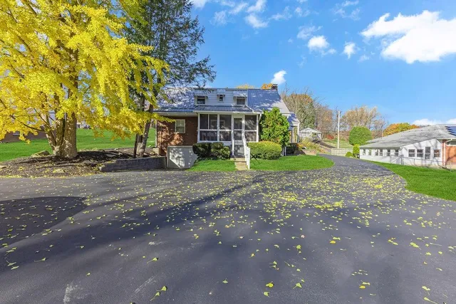 a view of a house with a yard and tree s