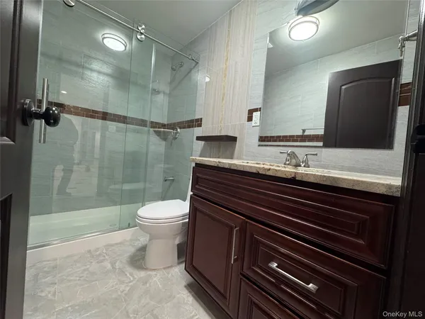 a bathroom with a sink a toilet and shower