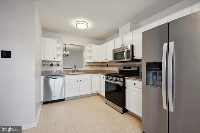 a kitchen with granite countertop a refrigerator stove and microwave