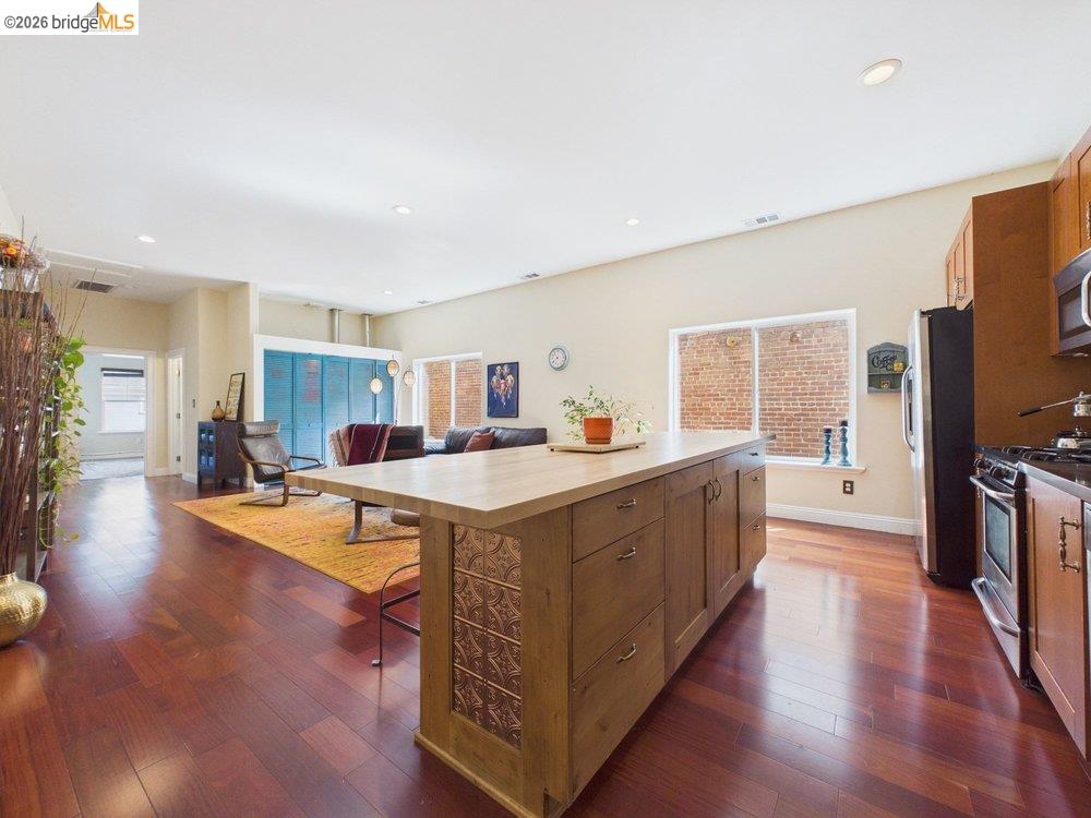 1488 14th Street, Unit A Oakland, CA 94607 - Photo 12 of 36 a large living room with stainless steel appliances granite countertop a lot of counter space and wooden floor