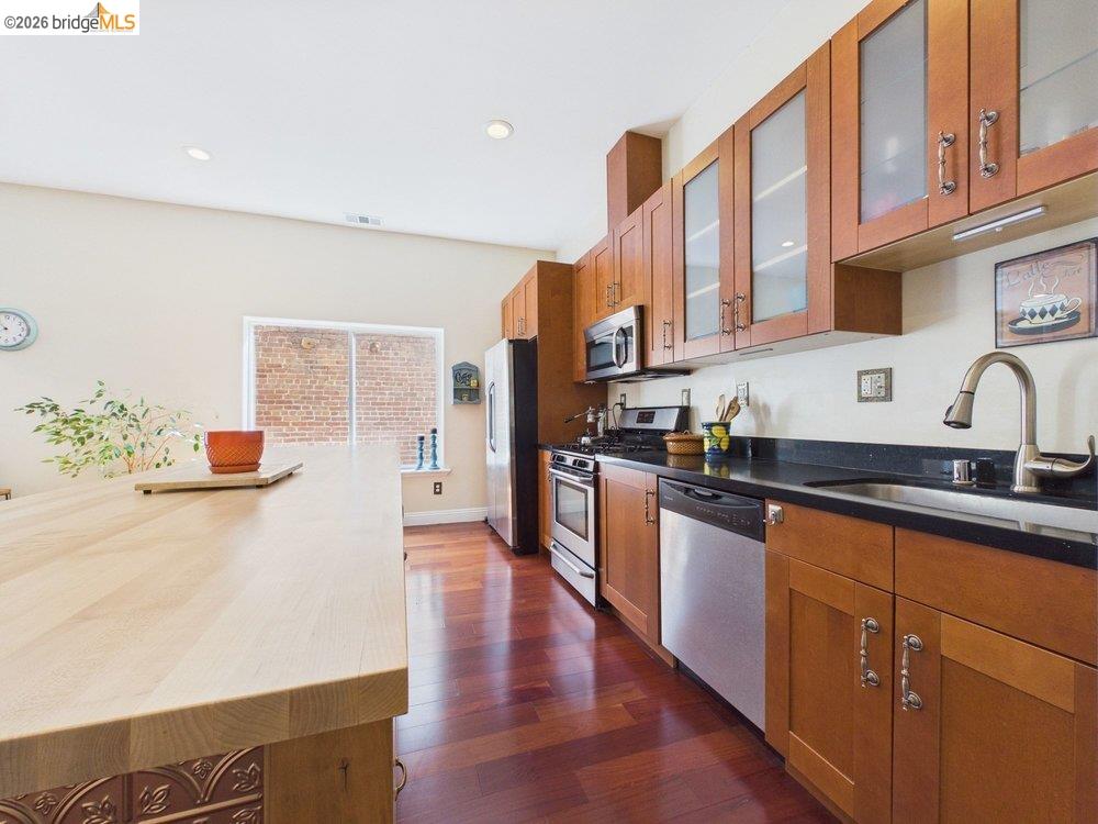 1488 14th Street, Unit A Oakland, CA 94607 - Photo 13 of 36 a kitchen with stainless steel appliances granite countertop a sink a stove top oven a counter space and cabinets