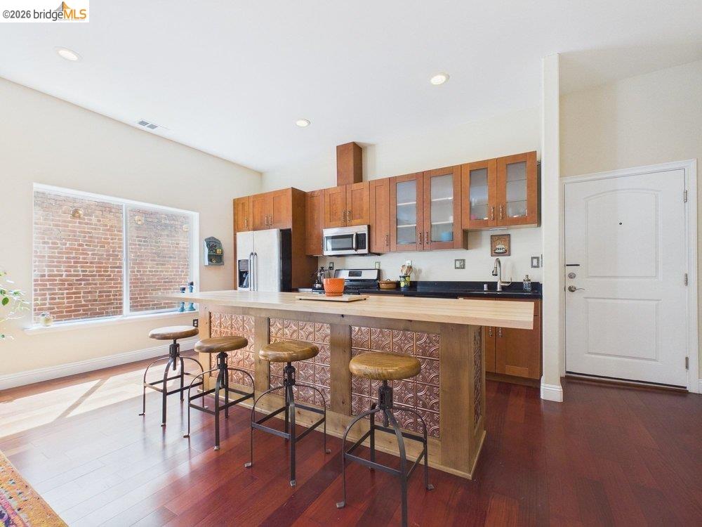 1488 14th Street, Unit A Oakland, CA 94607 - Photo 9 of 36 a living room with stainless steel appliances granite countertop furniture wooden floor and a large window