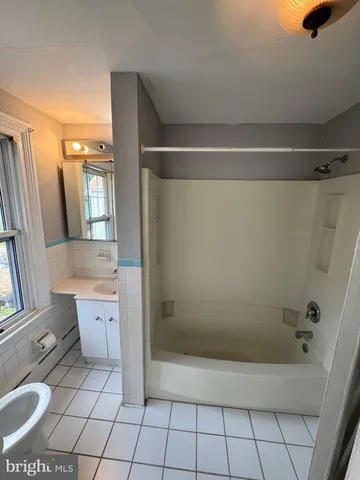 a bathroom with a granite countertop sink a toilet and shower