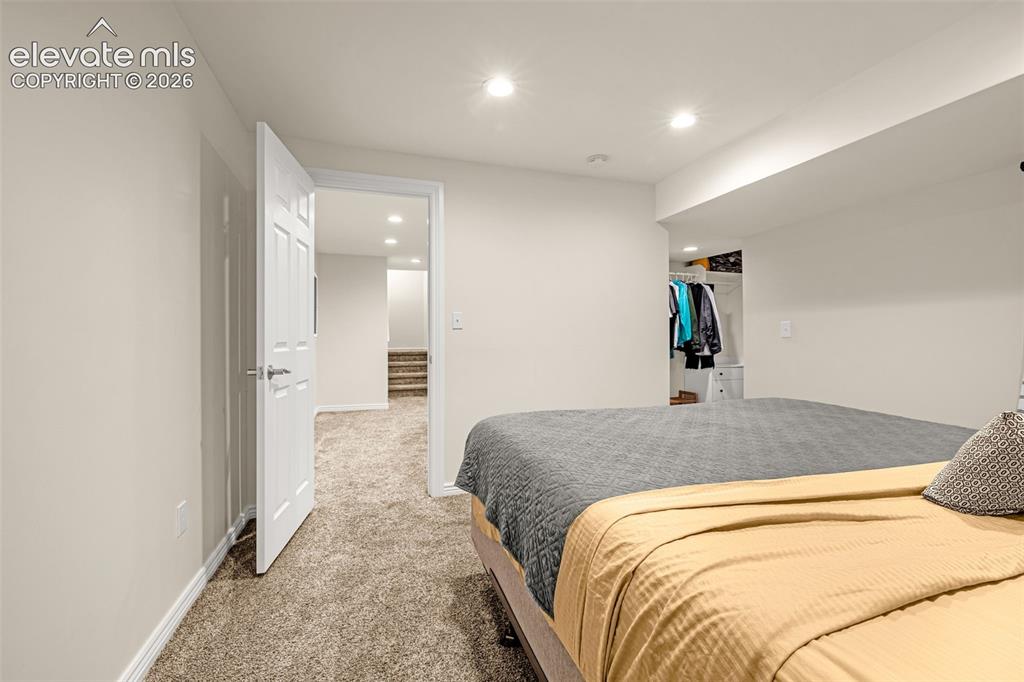 9127 Oakmont Road Peyton, CO 80831 - Photo 37 of 49 a spacious bedroom with a bed and a mirror