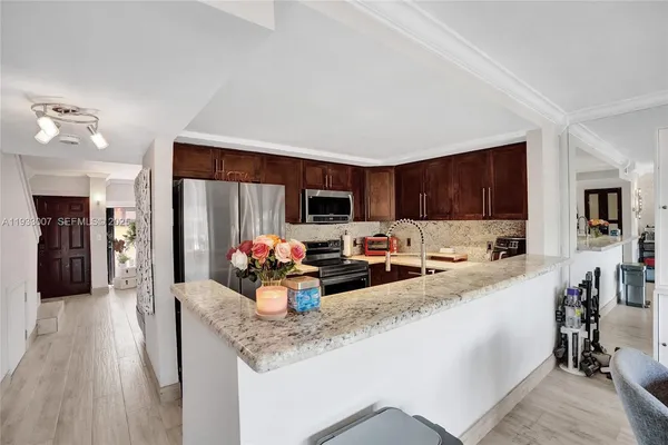 a kitchen with stainless steel appliances granite countertop a refrigerator stove and microwave