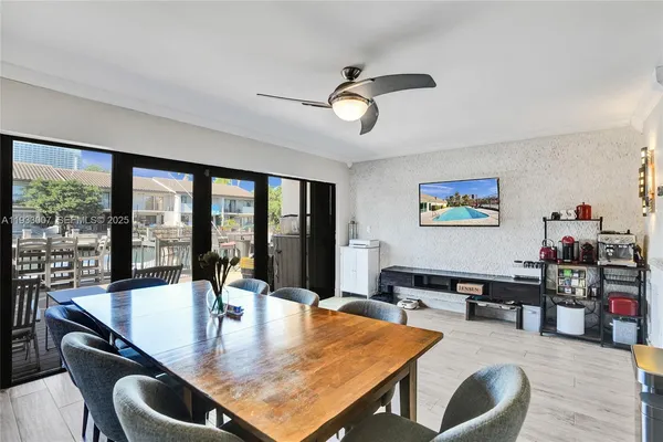a dining hall with stainless steel appliances kitchen island granite countertop a dining table and chairs with wooden floor