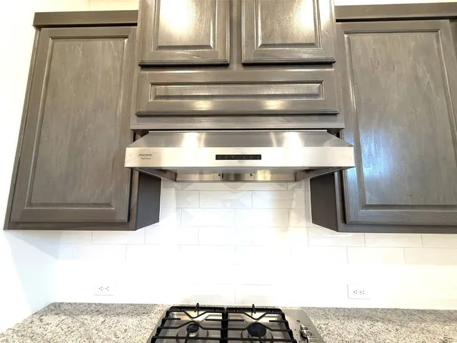 a kitchen with stainless steel appliances granite countertop a sink and dishwasher a stove top oven with wooden floor