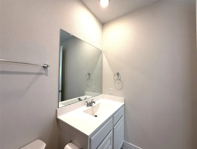 a bathroom with a sink mirror and vanity