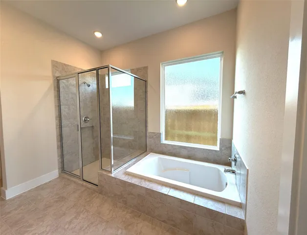 a spacious bathroom with a bathtub and a shower