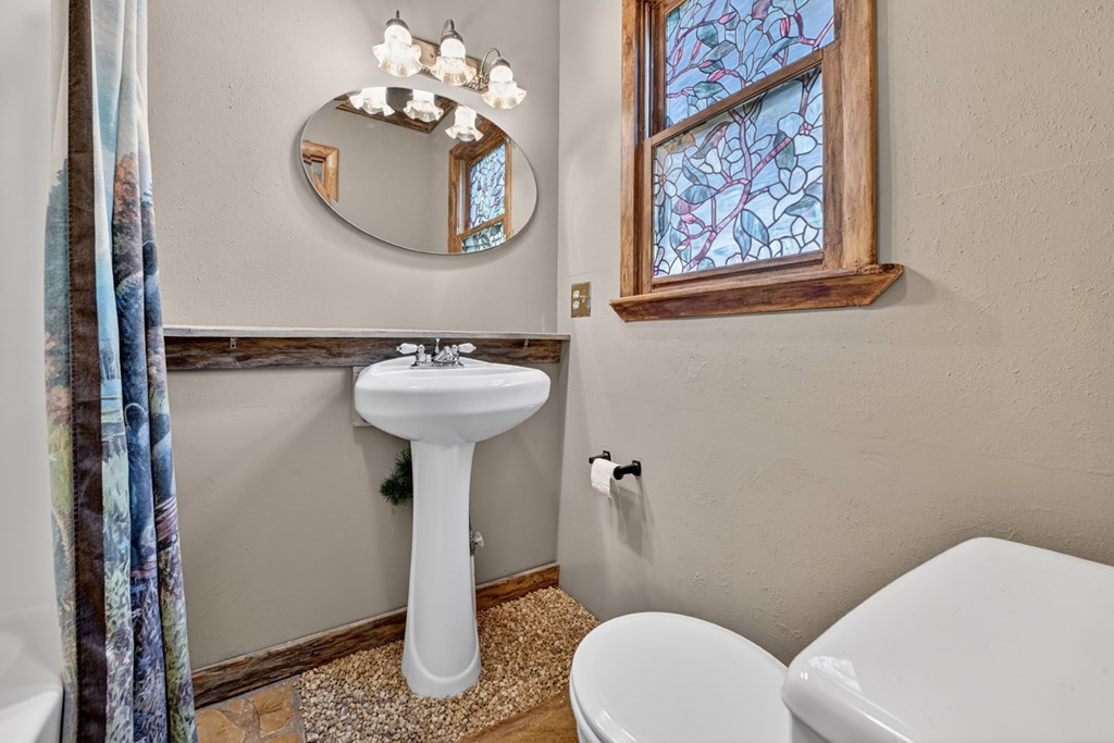 111 Candlewood Lane Blue Ridge, GA 30513 - Photo 56 of 57 a bathroom with a toilet sink and mirror
