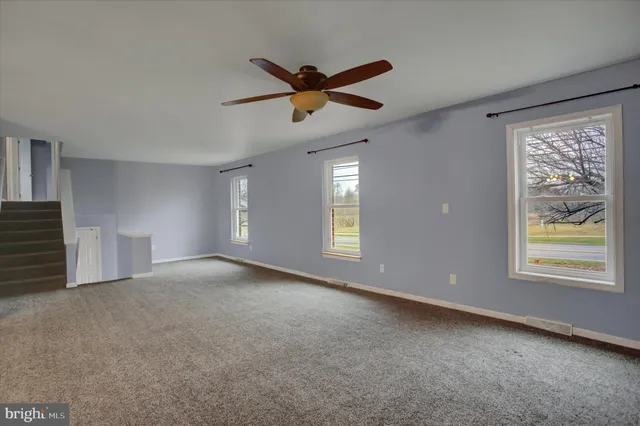 a view of a livingroom with a ceiling fan and window