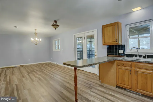 a view of a kitchen with granite countertop a sink and dishwasher with wooden floor