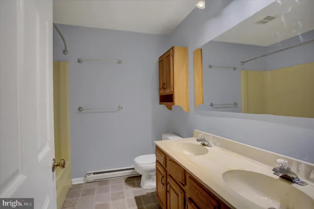 a bathroom with a sink a toilet and a mirror