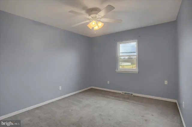 an empty room with window and closet area