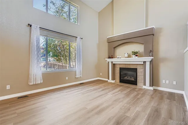a view of an empty room with a fireplace and a window