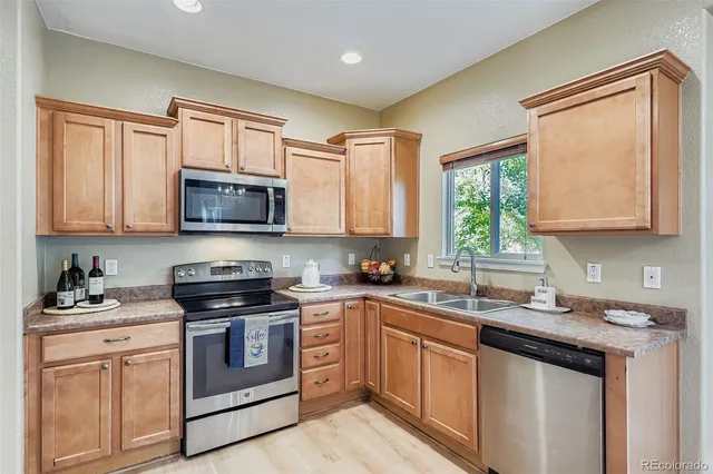 a kitchen with stainless steel appliances granite countertop white cabinets granite counter tops and a window