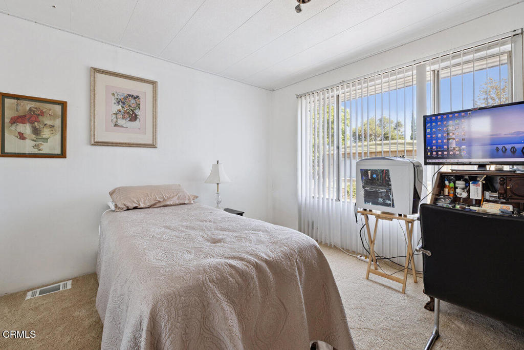 1550 Rory Lane, Unit 82 Simi Valley, CA 93063 - Photo 25 of 27 a bedroom with a bed and wooden floor