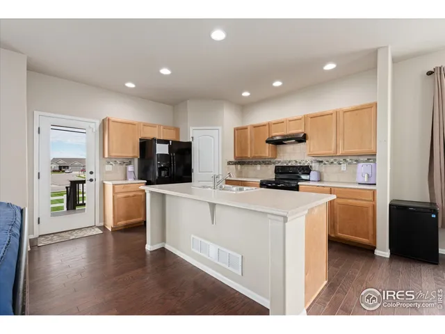 a kitchen with stainless steel appliances granite countertop a sink a stove and a refrigerator