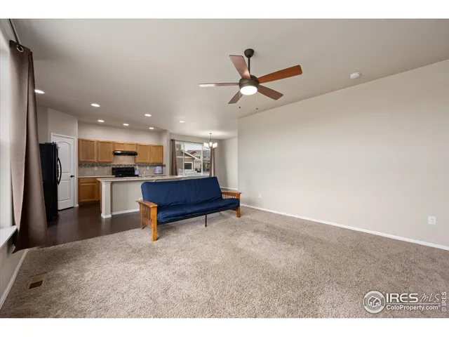 a view of an empty room with a window and a ceiling fan