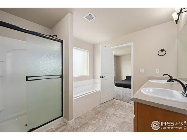 a bathroom with a sink vanity granite tub and a mirror